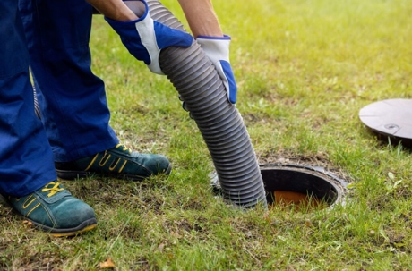 A worker pumps out a septic tank