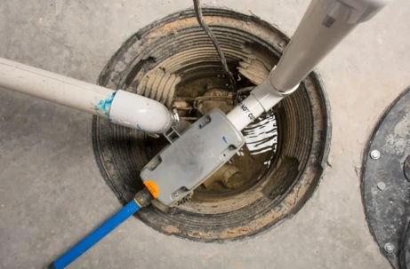 A top-down shot shows a sump pump in a concrete basement floor.