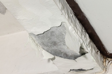 The damage could indicate water damage or a structural issue.