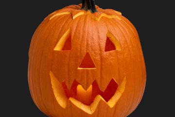 A classic Jack O'Lantern glows with a candle inside