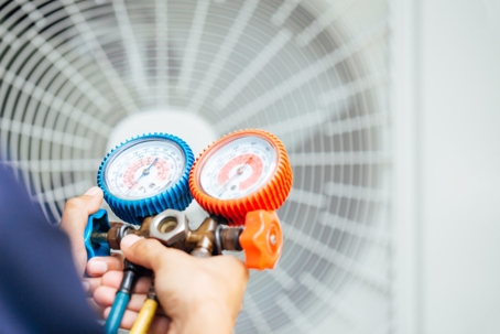 A technician is servicing an air conditioner unit