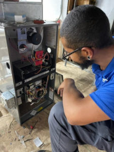 Money-Saving Tips in Cooler Temps 16 A technician kneels while inspecting the interior of an open furnace