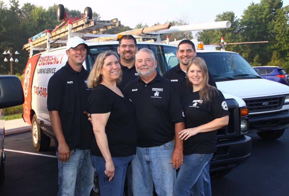 This Is Us 25 A group of six people stand smiling in front of an "Emergency Plumbing Service" van